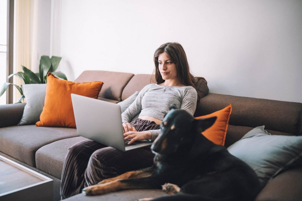 Kobieta z psem przy laptopie